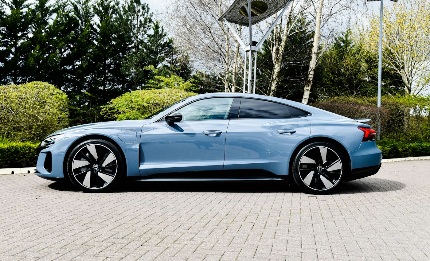 A light blue saloon photographed from the side on a paved road