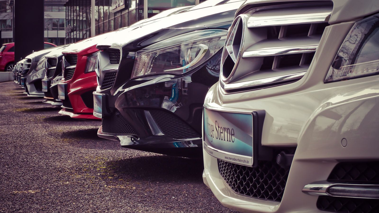 A row of cars displayed on a dealership forecourt