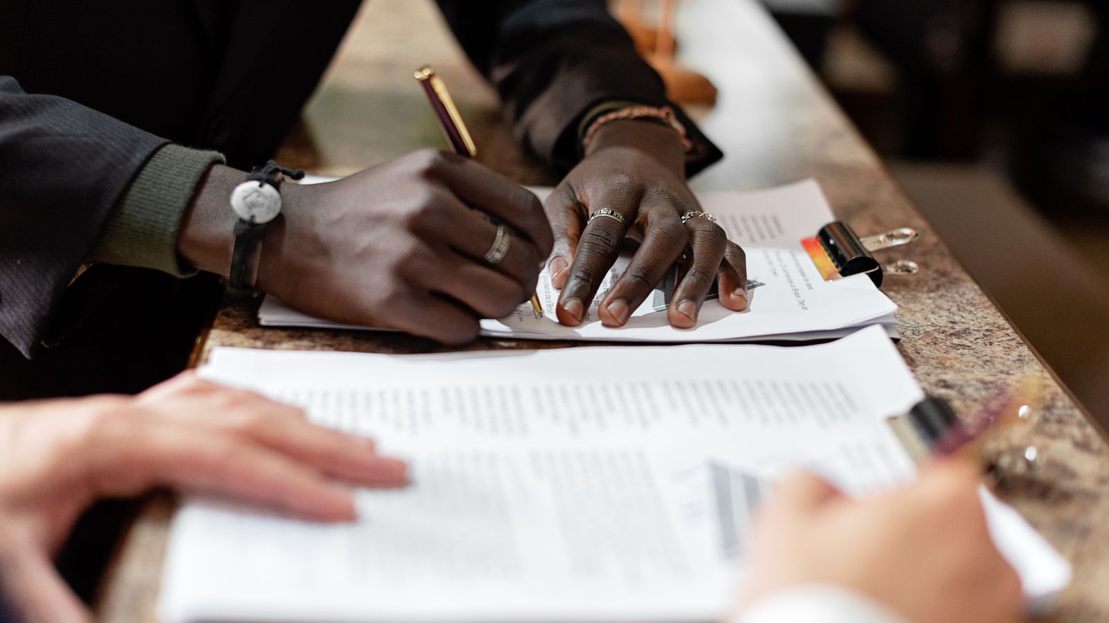 People reviewing and signing paperwork across a table