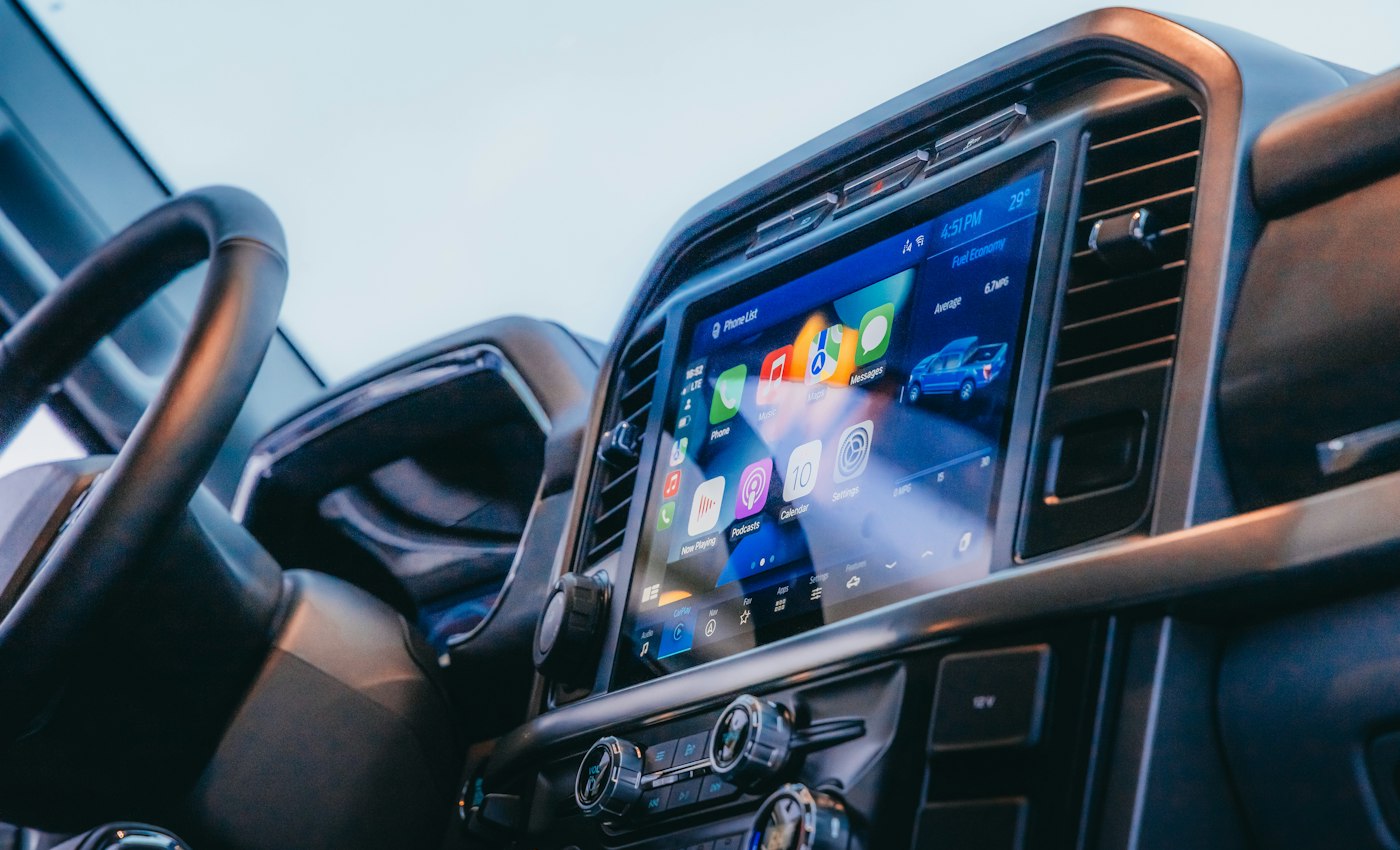 A car dashboard with a central touchscreen and air vents