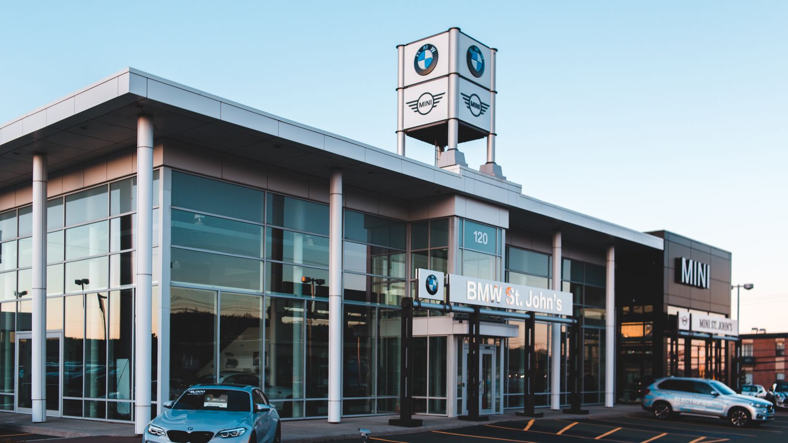 Cars outside a glass-fronted BMW and MINI dealership