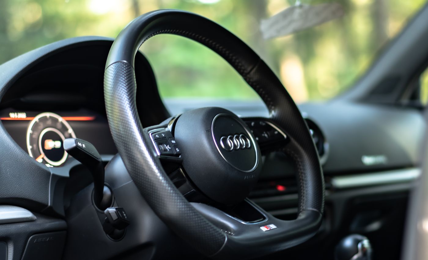 A detailed view of an Audi steering wheel and digital dashboard